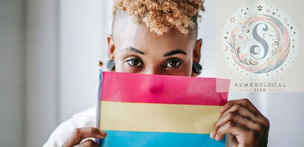 Mujer negra tatuada mostrando la bandera del orgullo pansexual